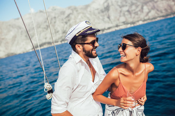 Loving couple spending happy time on a yacht at sea. Luxury vacation on a seaboat.