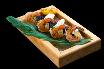 Tiger prawns with black rice and Philadelphia cheese custards, served on Himalayan salt