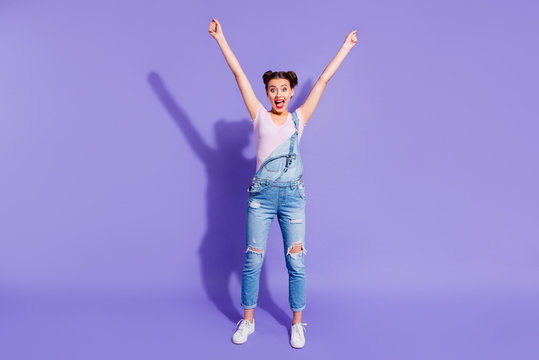 Full length body size photo beautiful funky she her lady two buns hands arms up show best emotions cheerleader wear casual t-shirt jeans denim overalls outfit isolated purple violet bright background