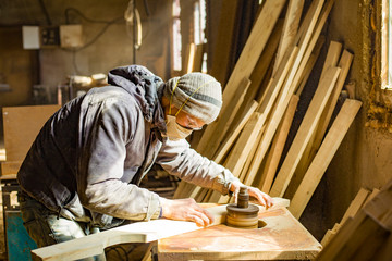 homemade milling machine, carpenter working on a wood sanding machine, wood workshop, worker in respirator