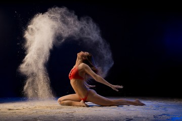 Obraz na płótnie Canvas Slim blonde in red lingerie in dust cloud shot