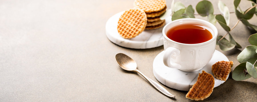 Cup of tea with syrupwaffles cookies