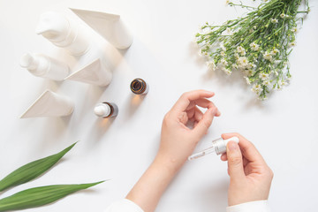 Dermatologist testing organic natural skincare products (serum, essential oil, cream, lotion) for...