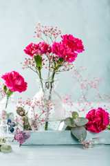 Bouquet of pink carnation on light turquoise wooden background