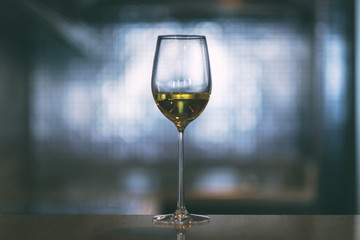 Closeup image of champagne in a wine glass with blurred light background