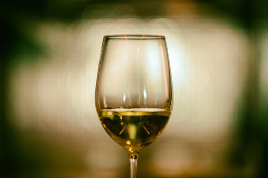 Closeup image of champagne in a wine glass with blurred light background