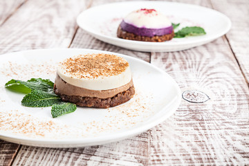 Close up view on two vegan raw cake on white wooden background with espresso cup. vegetarian dessert for breakfast. Healthy food with copy space for design and text.