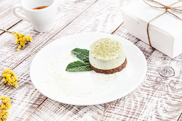 Close up view on vegan raw Matcha cake on white wooden background with espresso cup. vegetarian dessert for breakfast. Healthy food with copy space for design and text.