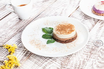 Close up view on vegan raw tiramisu cake on white wooden background with espresso cup. vegetarian dessert for breakfast. Healthy food with copy space for design and text.