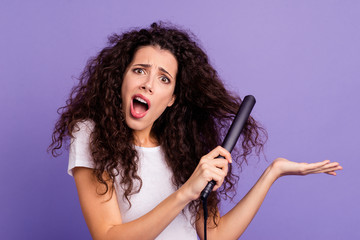 Close-up portrait of nice cute lovely groomed attractive doubtful wavy-haired lady using new electric product high temperature ironer isolated on bright vivid shine violet pastel background