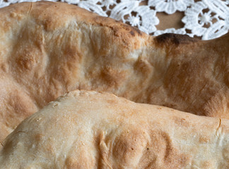 On the table are two flat cakes of delicious fresh bread.