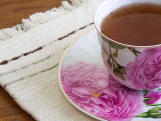 Tea in a colorful cup. Cup with tea on a cloth napkin.