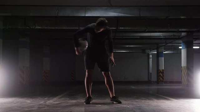 A young soccer man training tricks with the ball. Spinning the ball on the finger and on the forehead
