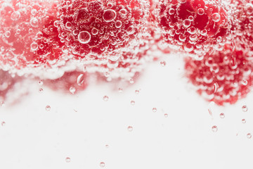 Fresh raspberries in water wiht air bubbles.