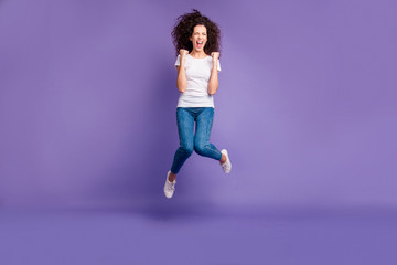 Full length body size photo yelling beautiful she her lady fists cheerleader jump high discount sale shopping wear casual jeans denim white t-shirt sneakers isolated purple violet bright background