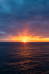 Cloudy sunrise view over the ocean horizon.