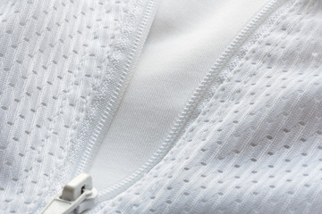 Detail of a white breathable sportswear with a zipper