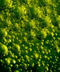 Suspended bubbles..Different sized metallic green balls flying in space.