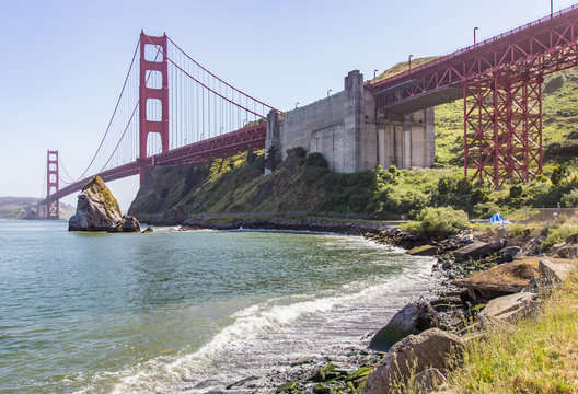 The Golden Gate Bridge is photographed from below in sunny weather.