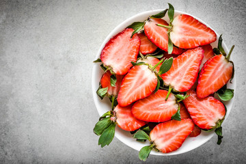 Fresh strawberry, top view. Plate with juicy slices of strawberries.