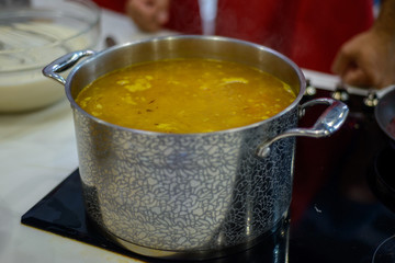 vegetable soup is brewed in a large saucepan on the stove