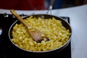 finely chopped apples are fried in sugar on a black frying pan