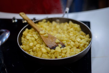 finely chopped apples are fried in sugar on a black frying pan