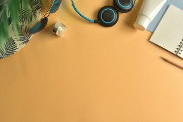 Fototapeta premium Flat lay, top view workspace with eye glasses, notebook, hat, sun block, shoes and coffee cup on yellow background. Summer stylish traveller blogger concept.