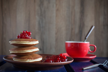 pancakes with jam on plate  on wooden background