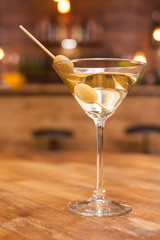 Alcoholic martini cocktail on a rustic wooden table in a restaurant