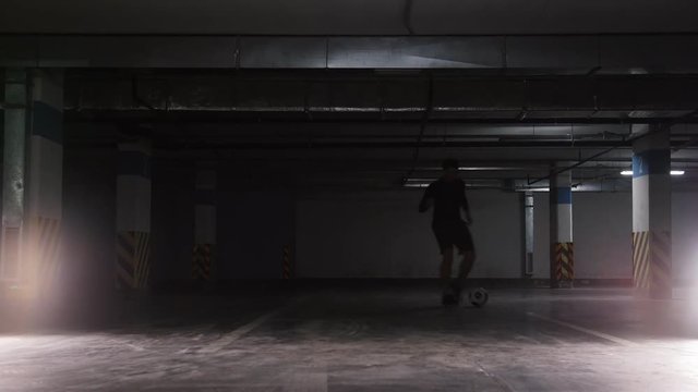 A soccer man leading the ball using feints on the underground parking lot