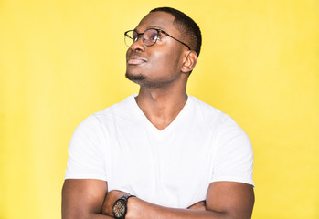 Portrait of a young handsome man with glasses on a yellow background.