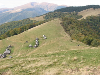 Mountain landscape with blue sky. View of the mountains and green hills from above.
