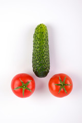 Tomatoes and cucumbers on white background in the form of penis.
