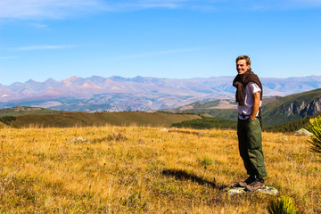 Naklejka na ściany i meble Tourist posing for photos on the background of the autumn landscape of the Altai mountains