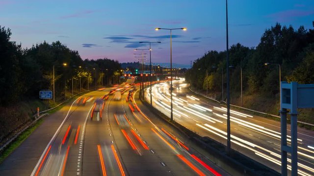 London Orbital motorway M25 with heavy traffic at rush hour. Cars driving at high speed. Time lapse.