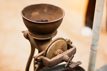 Grinding coffee by hand by an ancient grinder. 