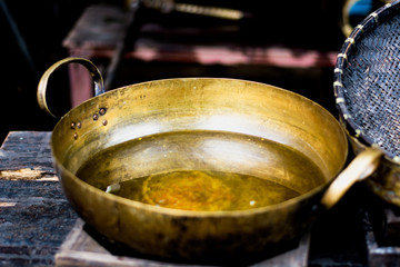 Antique brass pan There is water in it Set on a wooden table.