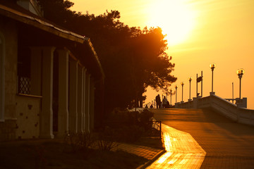 people walk on the promenade in the evening at sunset