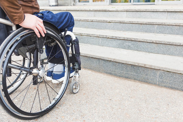 Man in wheelchair in front of stairs.