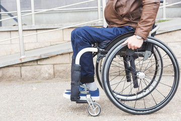 Man in a wheelchair use a wheelchair ramp.