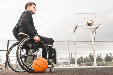Young man in a wheelchair playing basketball.