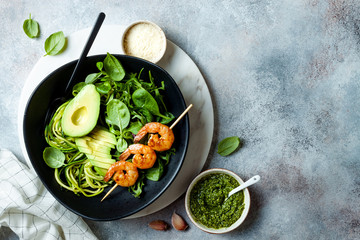 Detox Buddha bowl with avocado, spinach, greens, zucchini noodles, grilled shrimps and pesto sauce....
