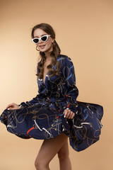 Crop of happy young girl in dark blue dress with pattern.