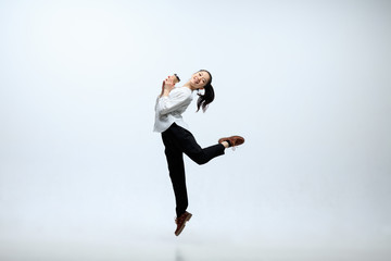 Happy to be part of the team. Woman working at office, jumping and dancing in casual clothes or...