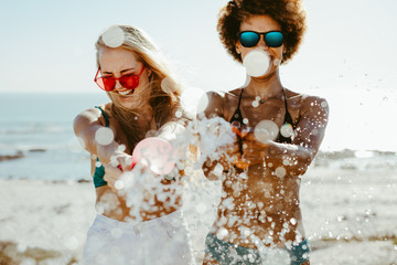Female friends playing with a water balloon