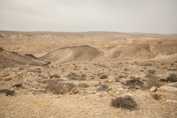 Obraz na płótnie Canvas Scenic view of sand, hills and rocks in Negev Desert in Mitzpe Ramon
