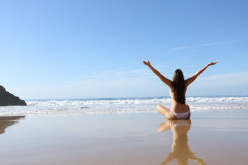 Happy woman in bikini celebrating vacation on the beach