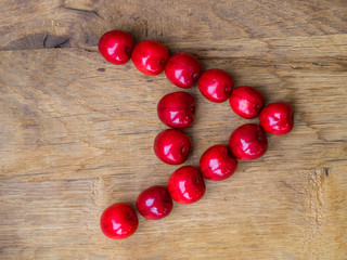 cherry on a wooden table as a letter