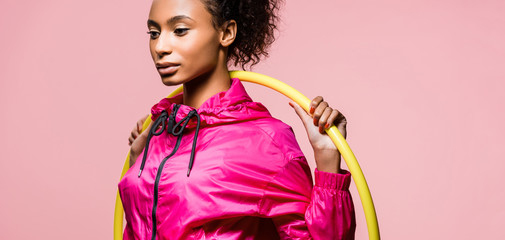 panoramic shot of beautiful african american sportswoman posing with hula hoop isolated on pink